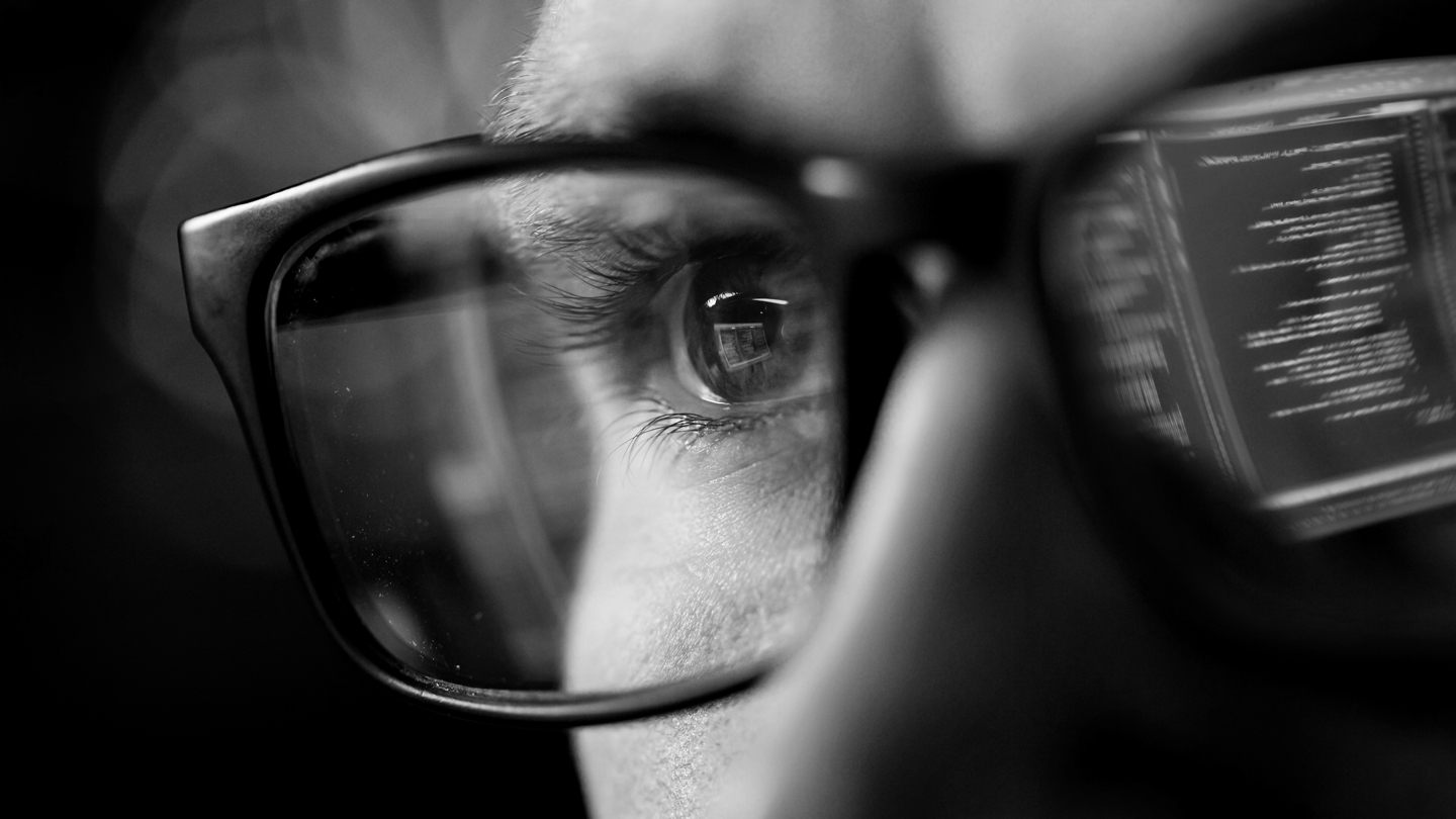 Persona con lentes reflejando código